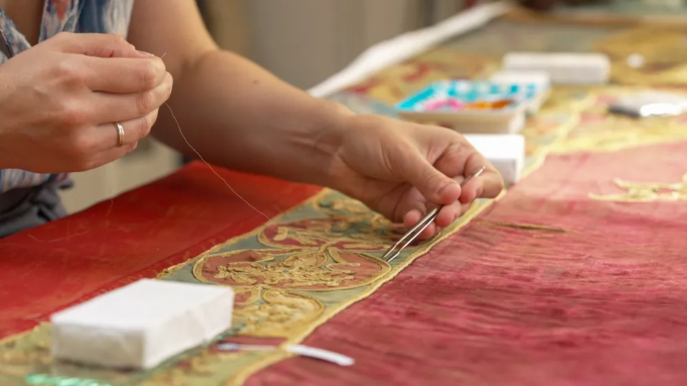 gros plan sur la restauration d'une tapisserie
